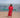 Woman in a red dress standing on a beach with boats in the background.  photographed in lombok, indonesia.  kaftan dress by lido luna. 