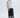 Woman wearing a white top and navy embroidered pants on a white background
