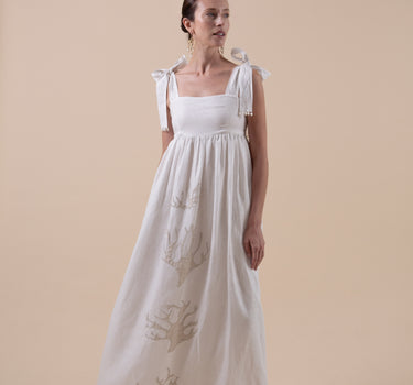The Lace Coral Dress is composed of 100% European Linen, with beaded applique coral motifs. It offers a comfortable adjustable fit and features delicate applique with glass beads, and real natural baroque pearls on trims.