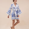 The Nerites dress is a short, popover style in 100% linen in a traditional but modernised kaftan style, with deep placket neckline and wide bell sleeves. Custom print by Fleur Kakasi, with hand embroidery and beading on the cuffs, hem, and double-length belt.