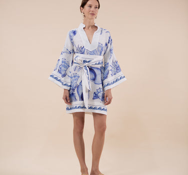 The Nerites dress is a short, popover style in 100% linen in a traditional but modernised kaftan style, with deep placket neckline and wide bell sleeves. Custom print by Fleur Kakasi, with hand embroidery and beading on the cuffs, hem, and double-length belt.