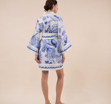 The Nerites dress is a short, popover style in 100% linen in a traditional but modernised kaftan style, with deep placket neckline and wide bell sleeves. Custom print by Fleur Kakasi, with hand embroidery and beading on the cuffs, hem, and double-length belt.