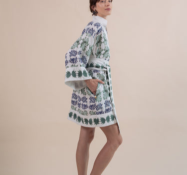 The Nerites dress is a short, popover style in 100% linen in a traditional but modernised kaftan style, with deep placket neckline and wide bell sleeves. Custom print by Fleur Kakasi, with hand embroidery and beading on the cuffs, hem, and double-length belt.