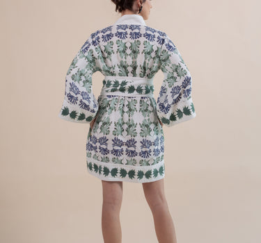 The Nerites dress is a short, popover style in 100% linen in a traditional but modernised kaftan style, with deep placket neckline and wide bell sleeves. Custom print by Fleur Kakasi, with hand embroidery and beading on the cuffs, hem, and double-length belt.