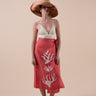 The Poseidon Wrap Skirt is a classic full-wrap style, below knee length, featuring extra long ties, and stunning applique and embroidery details on coral red linen. 
 The contrasting ivory applique features our signature coral motif, with glass pearl beads, and each tie features real natural baroque pearl charms at each end. Design by Fleur Kakasi